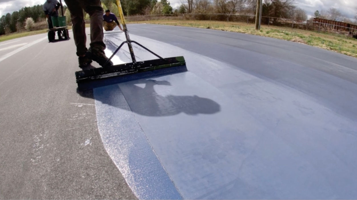Crew installing Polypave across an asphalt tennis court